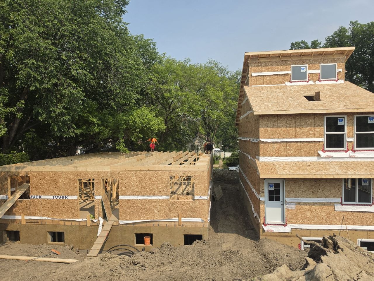Wood-framed addition beside an existing two-storey house